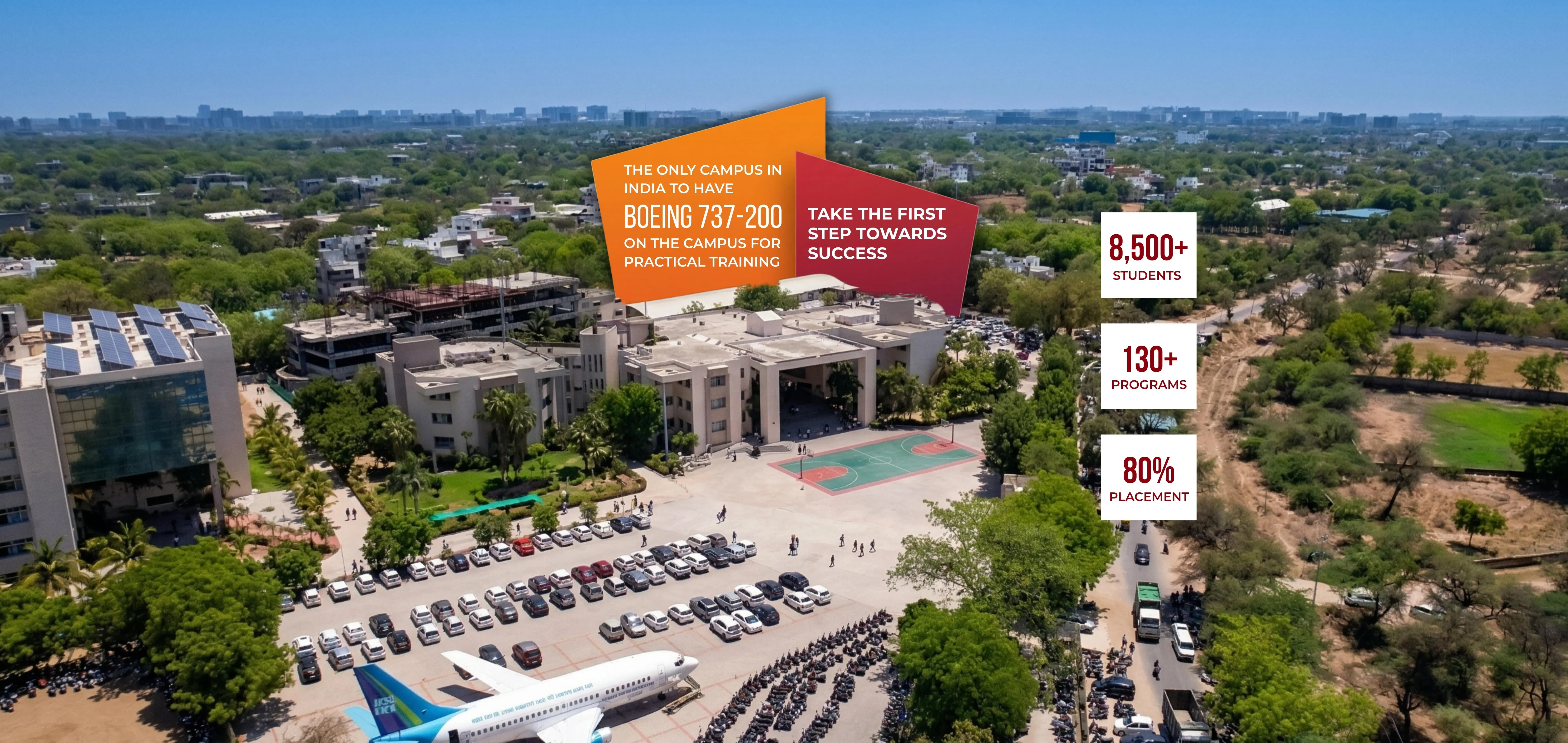Aerial view of the Indus University campus in India. Text overlays highlight it as the only campus in India with a Boeing 737-200 for practical training, alongside key statistics: 8,500+ students, 130+ programs, and an 80% placement rate.